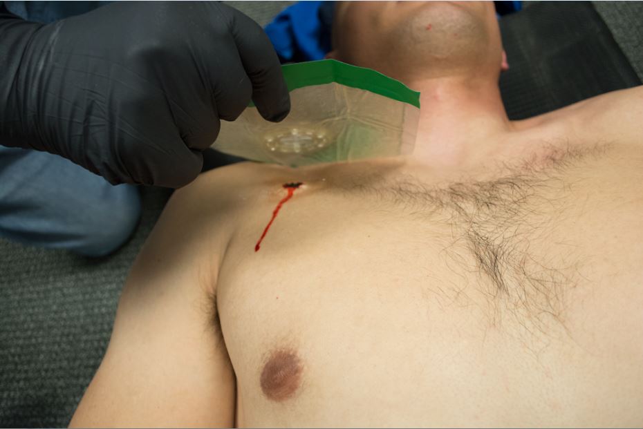 A man with a scalpel is cutting his chest.
